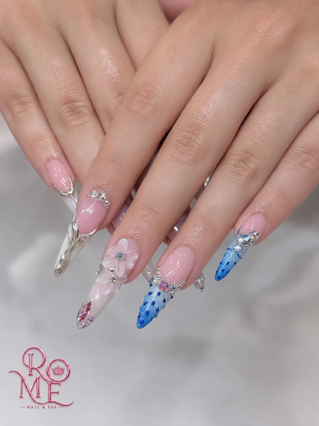 Silver, blue, and sculpted floral nail art by Rome Nails Spa